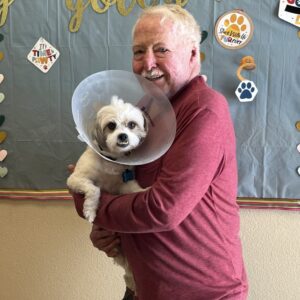 a man adopting a small white dog at Valley Humane Society